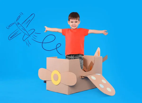 Roztomilé Malé Dítě Hraje Lepenkovém Letadle Modrém Pozadí Ilustrací — Stock fotografie