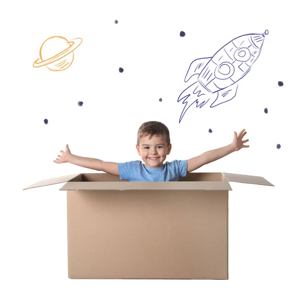 可爱的小男孩在白色背景的纸板箱里玩附有插图的游戏 — 图库照片
