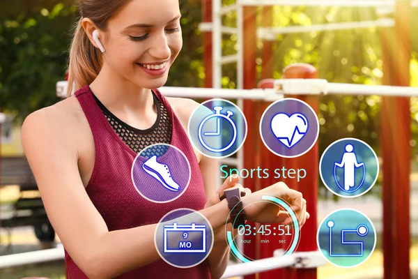 Woman using smart watch during training outdoors. Icons near hand with device