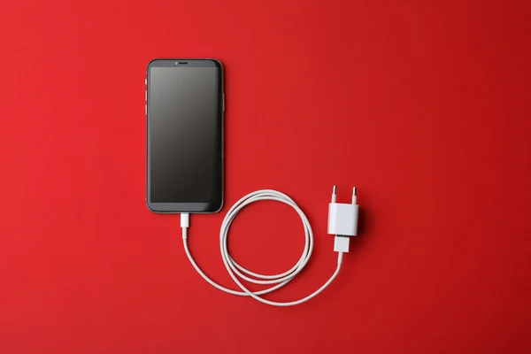 Smartphone Och Usb Laddare Röd Bakgrund Platt Låg Modern Teknik — Stockfoto