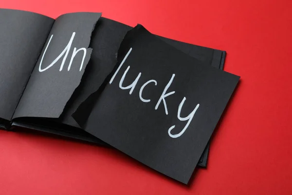 Torn Word Unlucky Written Notebook Red Background — Stock Photo, Image