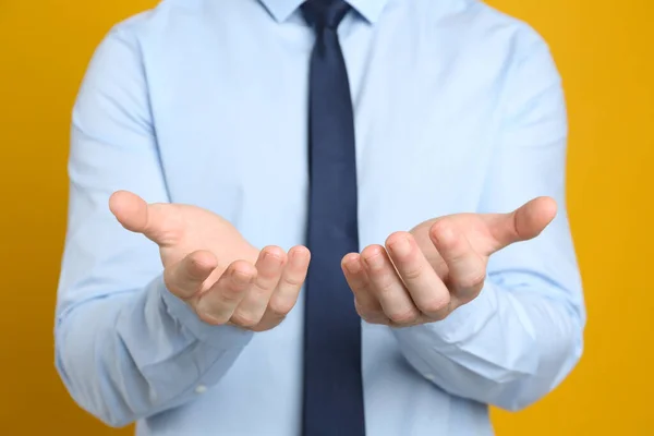 Empresario Sosteniendo Algo Contra Fondo Naranja Centrarse Las Manos — Foto de Stock