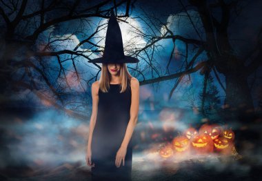Cadılar Bayramı 'nda dolunay altında balkabağı ve sisli ormanı olan korkunç Jack O Lantern cadısı.