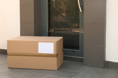 Kapıya yakın yerde karton kutu var. Paket teslimat servisi