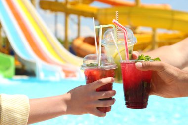 Su parkında ferahlatıcı içkileri olan insanlar, yakın çekim.