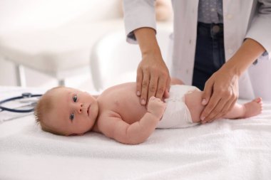 Doktor sevimli bebeği içeride muayene ediyor, yakın plan. Sağlık hizmetleri