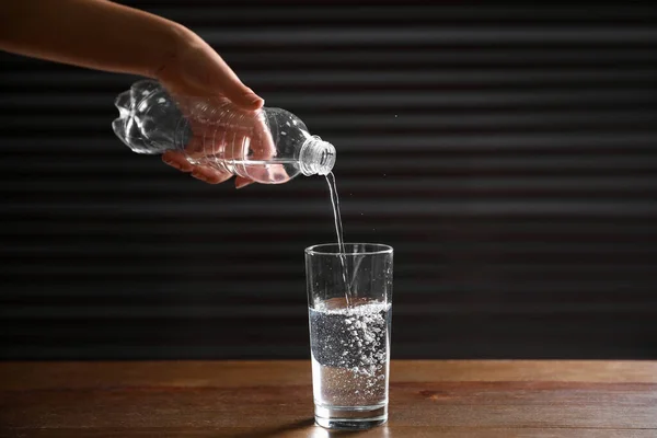 Woman Pouring Water Bottle Glass Wooden Table Dark Background Closeup — Stock Photo, Image