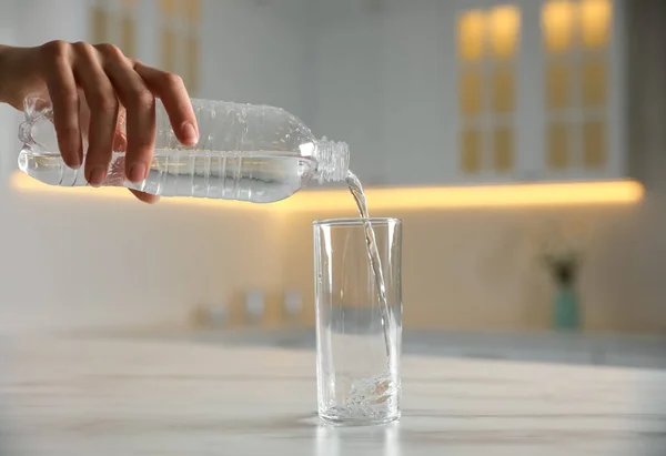 Donna Versando Acqua Dalla Bottiglia Vetro Sul Tavolo All Interno — Foto Stock