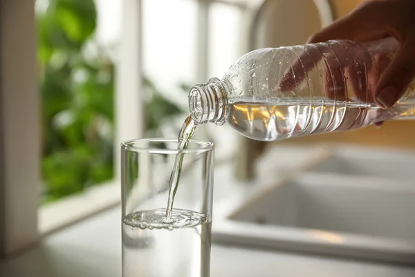 Vrouw Gieten Water Uit Fles Glas Keuken Close — Stockfoto