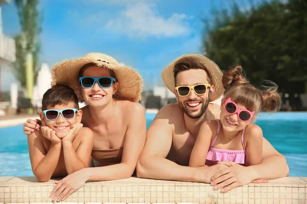 Happy family in swimming pool on sunny day