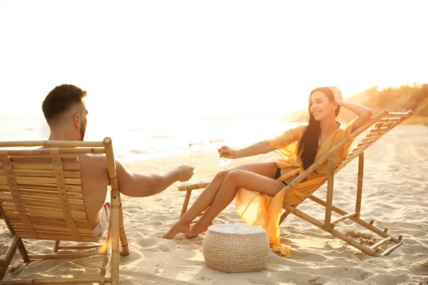 浪漫的夫妻日落时一起在海滩上喝酒 — 图库照片