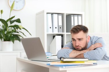 Tembel genç adam ofiste vakit harcıyor.