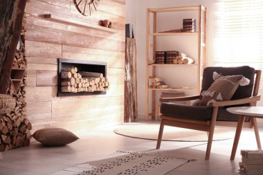 Oturma odasının iç kısmında odun istiflenmiş dekoratif şömine.