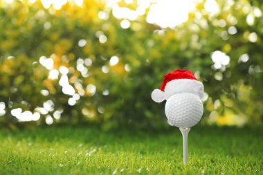 Bulanık arka planda küçük Noel Baba şapkalı golf topu. Metin için boşluk