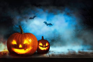 Korkunç Jack O Lantern balkabakları ve uçan yarasalar Cadılar Bayramı 'nda sisli ormanda. Metin için boşluk