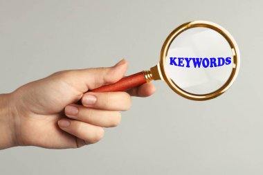 Kadın büyüteçten kelimeye bakıyor, yakın plan.