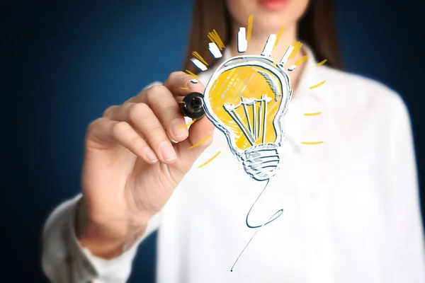 アイデアのコンセプト ビジネスの女性が仮想画面上で光る電球のイラストを描く クローズアップ — ストック写真