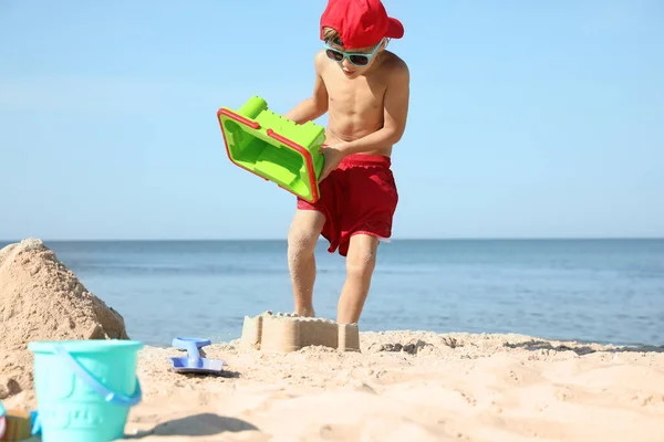 Niedliches Kleines Kind Spielt Sonnigen Tagen Sandstrand Mit Plastikspielzeug — Stockfoto