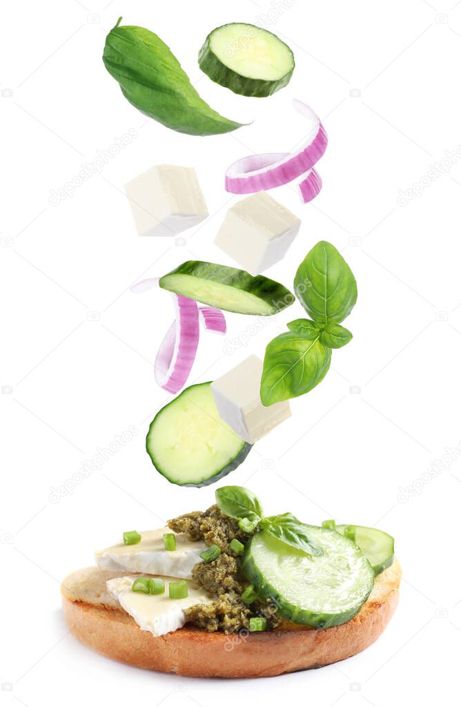 Tasty bruschetta with flying ingredients on white background