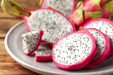 Delicious cut dragon fruit (pitahaya) on wooden table, closeup clipart