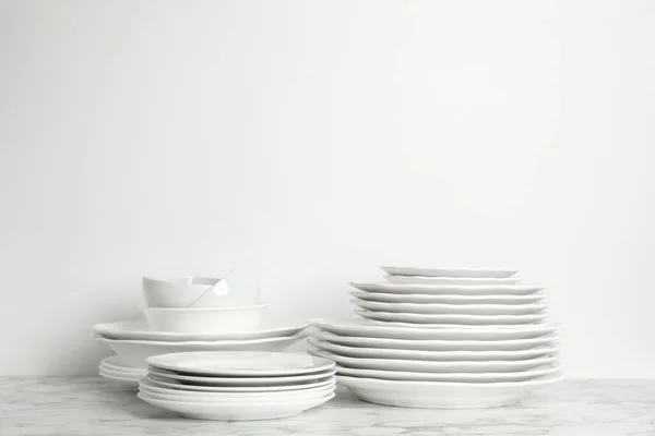 一套白色背景的大理石桌上干净的盘子和碗 案文的篇幅 — 图库照片