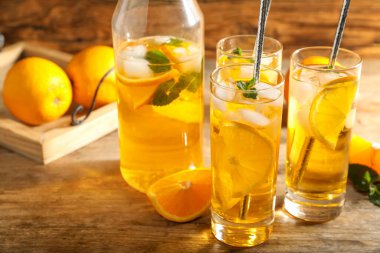 Ahşap masada portakal dilimleri ile nefis bir içecek.