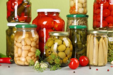 Kavanozlar dolusu sebze ve malzemeler ışık masasında.