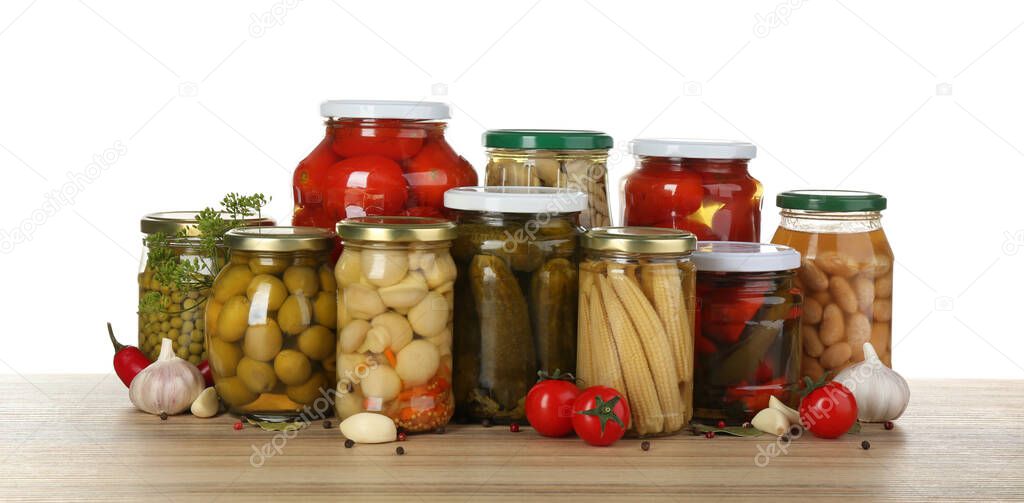 Jars of pickled vegetables on wooden table