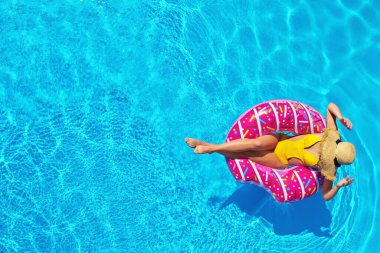 Yüzme havuzunda şişirilebilir yüzüklü genç bir kadın. Metin için boşluk