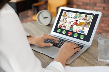 Öğretmen Covid-19 salgınından dolayı karantina ve sosyal uzaklık sırasında online okul dersi veriyor. Öğrenciler video konferansı yoluyla evde çalışıyorlar
