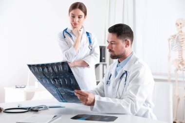Ortopedistler klinikteki masada röntgen filmini inceliyor.