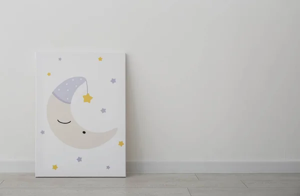 Adorable picture of moon and stars on floor near white wall, space for text. Children\'s room interior element