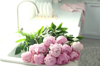 Mutfak lavabosunda bir buket pembe şakayık.