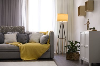 Pencerenin yanında rahat kanepesi olan şık bir oturma odası. İç tasarım