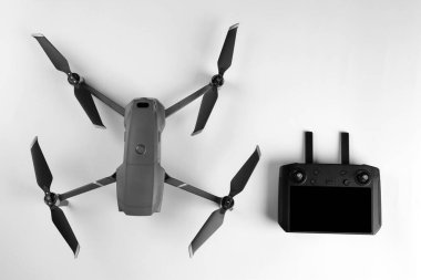 Beyaz zemin üzerinde denetleyici ile modern drone, üst görünüm