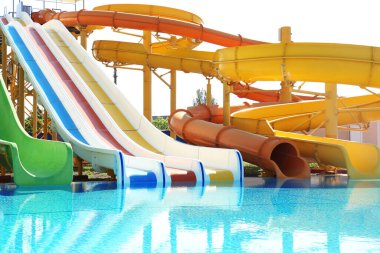 Güneşli bir günde su parkında farklı renkli slaytlar