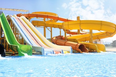 Güneşli bir günde su parkında farklı renkli slaytlar