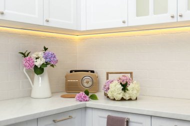 Güzel ortanca çiçekleri ve radyo ışıklı tezgahın üstüne kurulmuş.