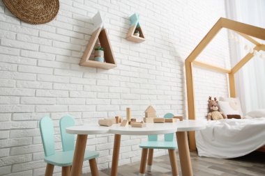 İçinde yatak ve küçük masa olan şirin bir çocuk odası.