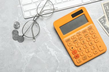 Hesap makinesi, gözlük, klavye ve para mermer masanın üstünde, düz konum. Vergi muhasebesi