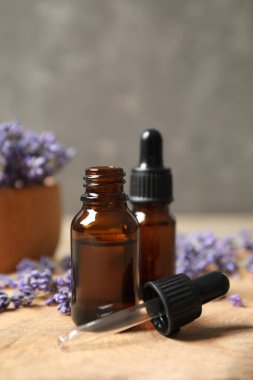 Ahşap masada gerekli yağ ve lavanta çiçekleri.