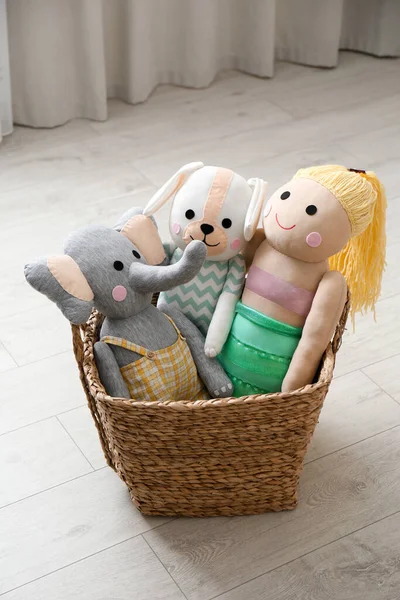 Funny toy elephant, dog and doll in basket on floor. Decor for children\'s room interior