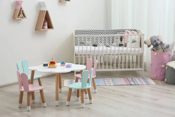 Niedliche Babyzimmereinrichtung Mit Kinderbett Und Kleinem Tisch — Stockfoto