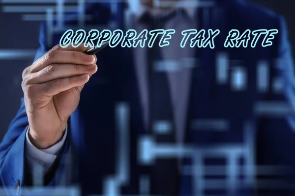 Corporate tax rate. Man writing on virtual screen against color background, closeup