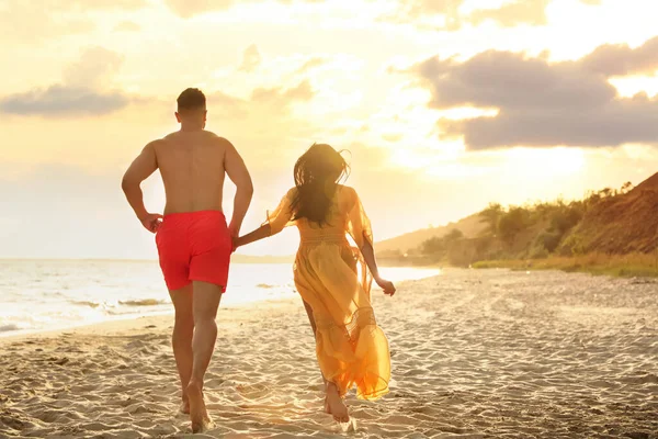 Schönes Paar Läuft Zusammen Strand Bei Sonnenuntergang Rückansicht — Stockfoto