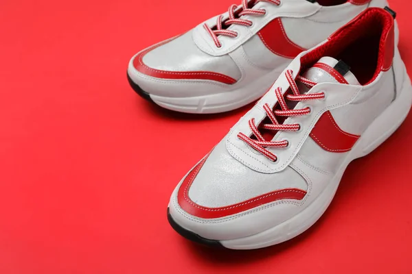 Een Paar Stijlvolle Sneakers Rode Achtergrond Close — Stockfoto