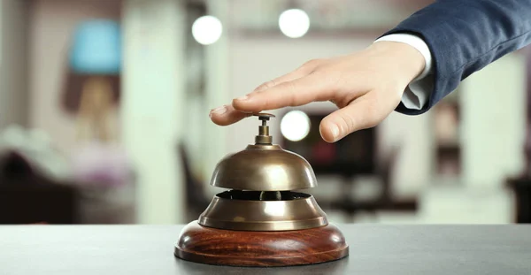 Man ringing hotel service bell on blurred background, closeup. Banner design