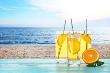 Kumlu plaja karşı ahşap masada nefis bir içecek.