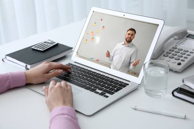 Masada iş eğitmeniyle görüntülü görüşme yapan bir kadın var.