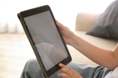 Modern tabletle çalışan bir kadın, kapalı mekanda, yakın plan. Tasarım için boşluk